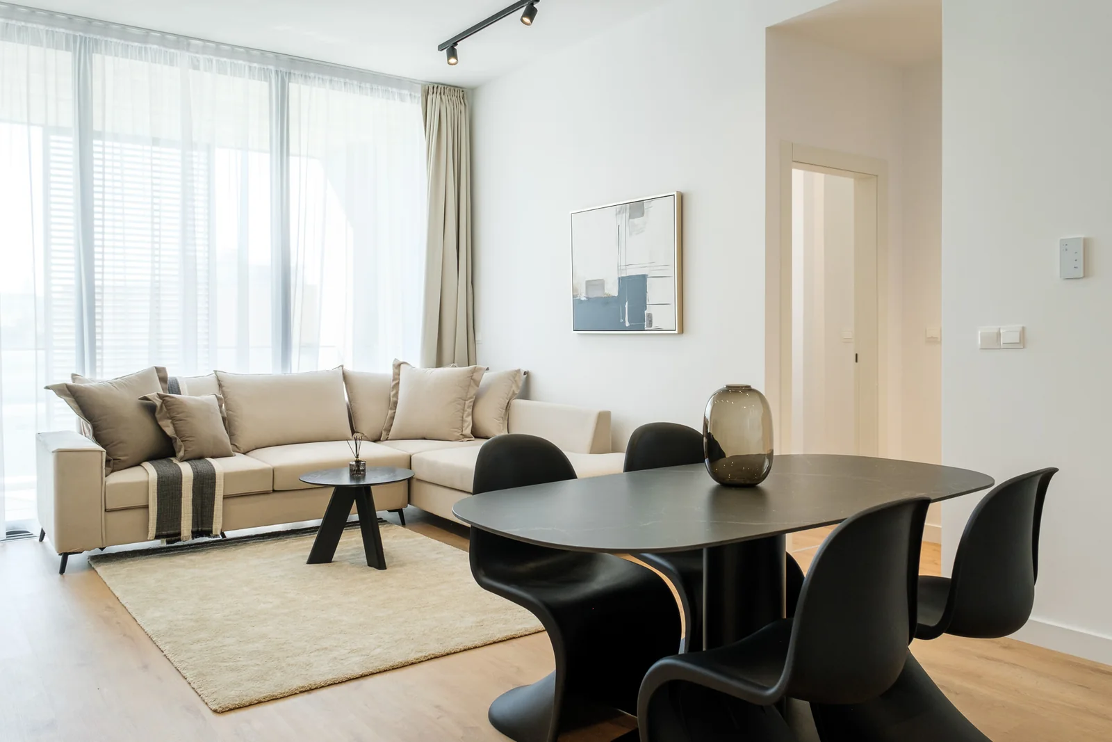 A fully furnished Molivin apartment with a light sofa and dining setting